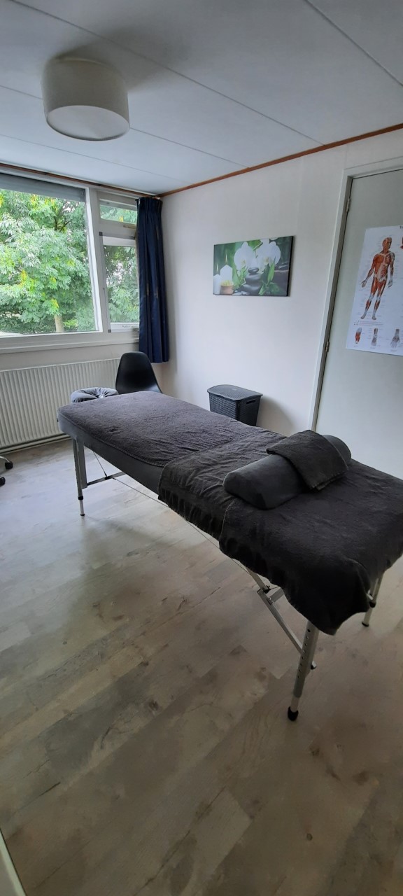 Massagetafel gezien vanaf het voeteneind, met het raam erachter